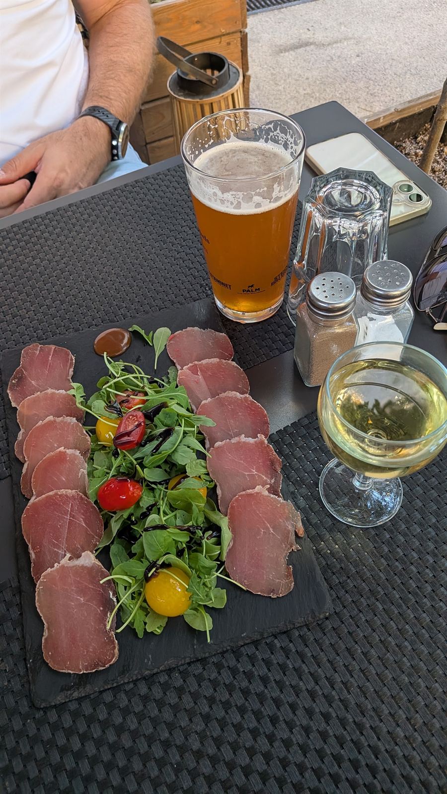 Fines tranches de viande séchée, roquette et tomates cerises, avec une bière