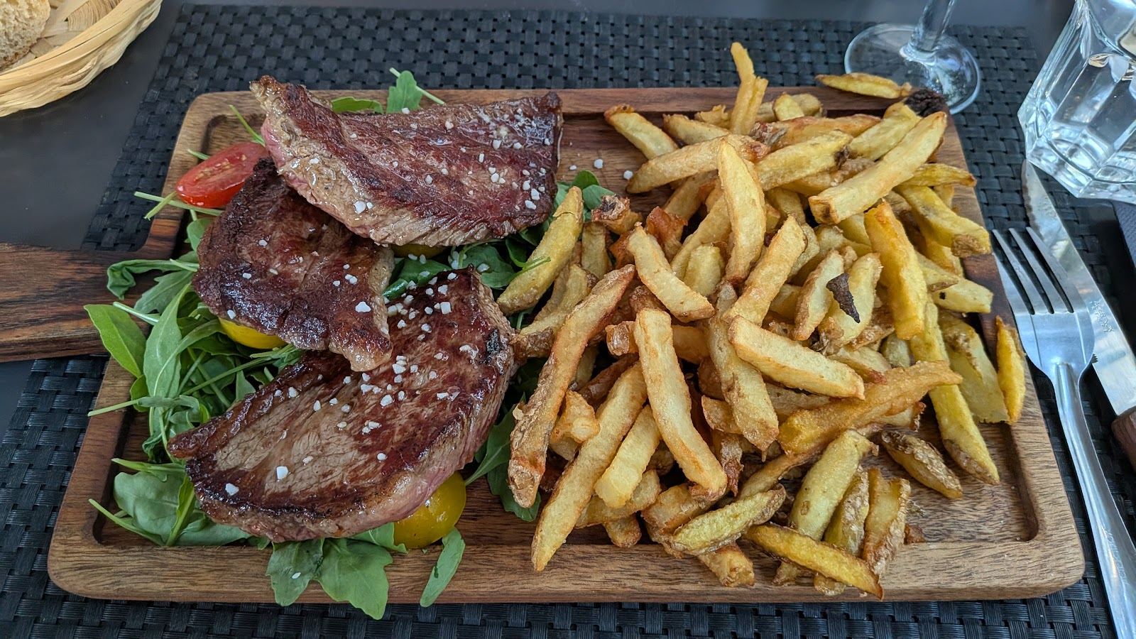 Planche en bois de viande grillée avec une grosse part de frites maison