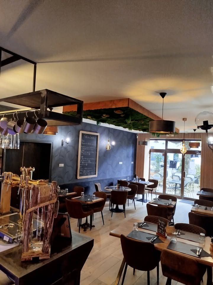 Le bar avec ses tireuses à bière, le plafond végétal et la baie vitrée