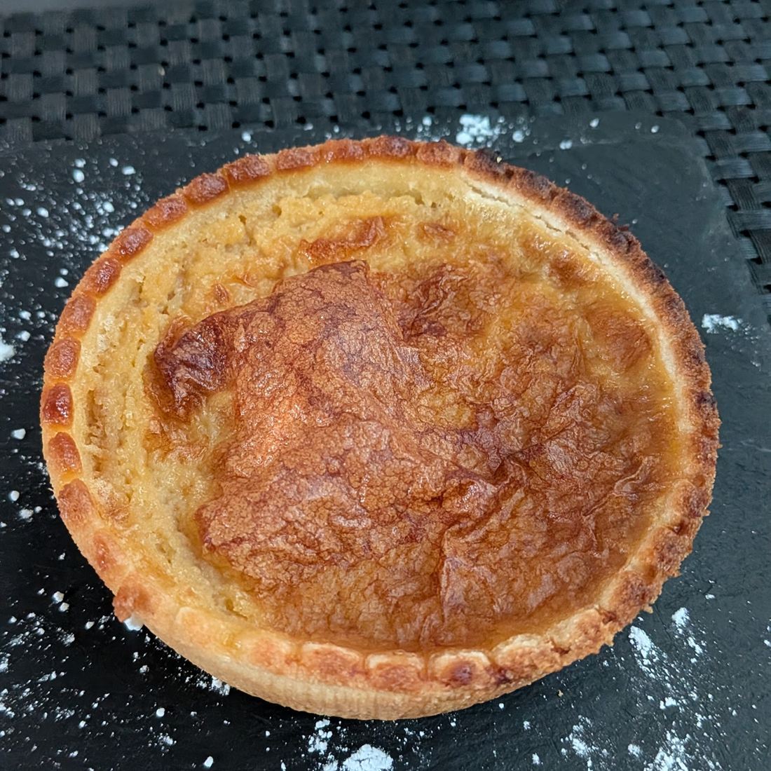 Tarte dorée posée sur une ardoise